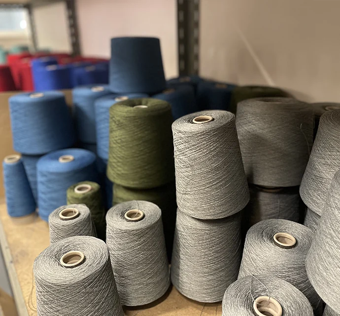 Cones of fine Schoeller wool yarn in KAMA’s Prague production facility
